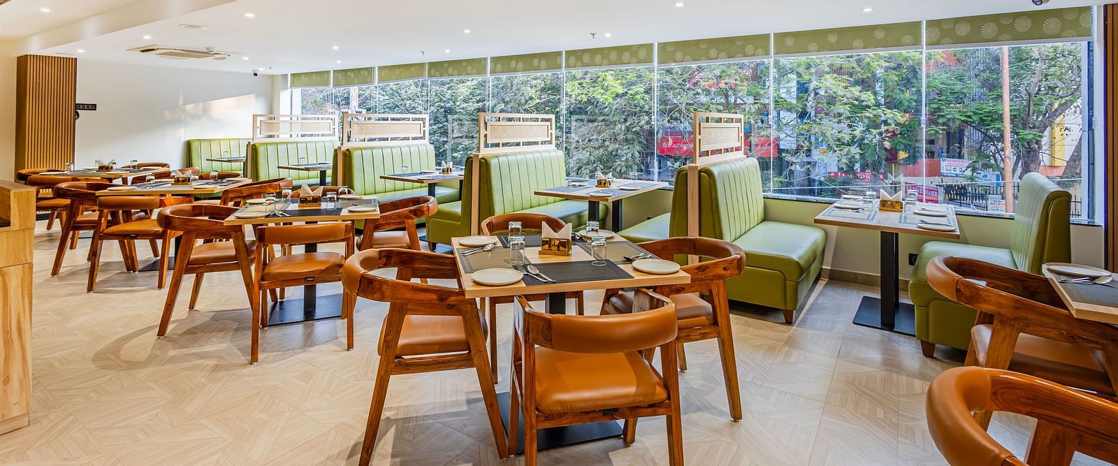 Lemonridge Hotels, KPHB | Dining area with tables and chairs, large windows overlooking greenery. Bright and airy space.